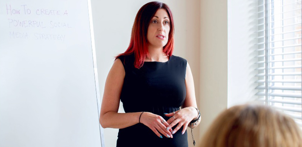 Digital marketing trainer, social media speaker, Jennifer Paukman in a black dress looking out at a crowd